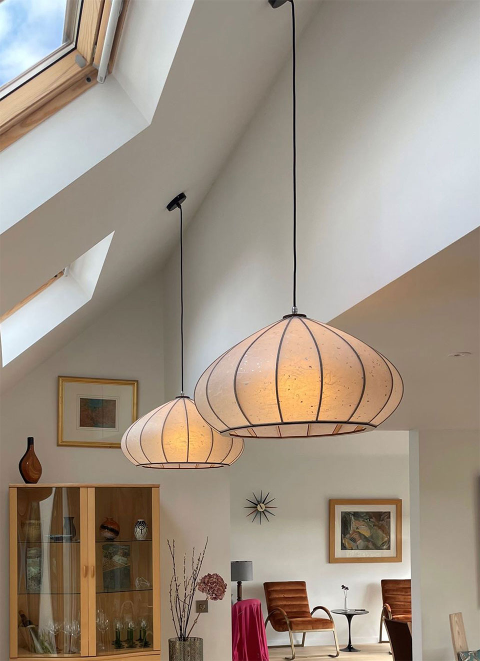 Handmade washi mushroom pendant above a dining table.